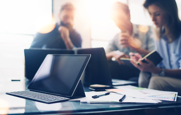 Business team at working process.Young professionals work with new market startup.Project managers meeting,mobile gadgets on the table.Panoramic windows on blurred background.Horizontal